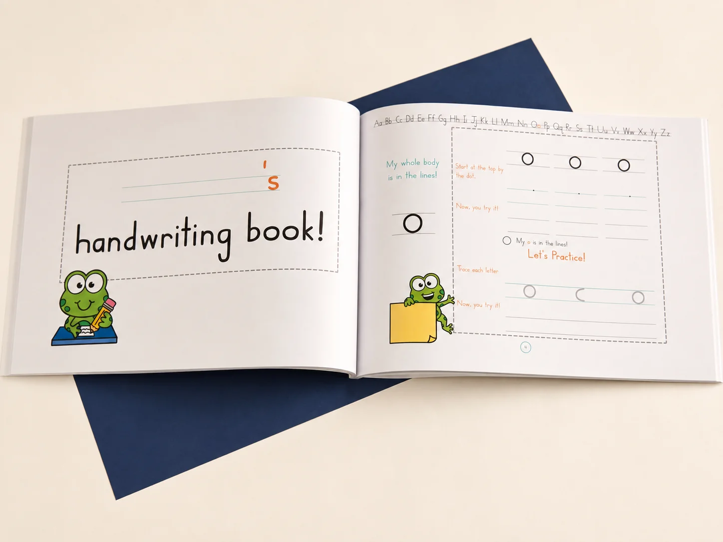 An open first grade handwriting workbook with letter tracing practice and a frog character